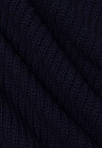 Marineblauwe gebreide stof met een ribbelstructuur, die golvende patronen vertoont en een zachte, fuzzy oppervlakte heeft.