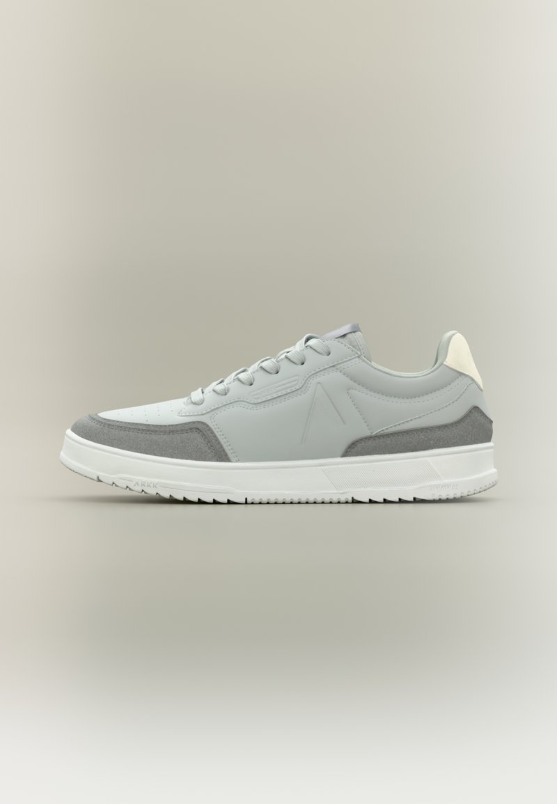 Sneaker grigio chiaro con suola bianca, materiali in pelle e camoscio, design con lacci, punta arrotondata e accenti del logo discreti sul lato.