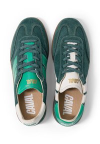 Paire de baskets en daim vert avec des accents en cuir blanc et vert contrastants, des lacets et un marquage "CAVAL" sur la languette et la semelle intérieure.