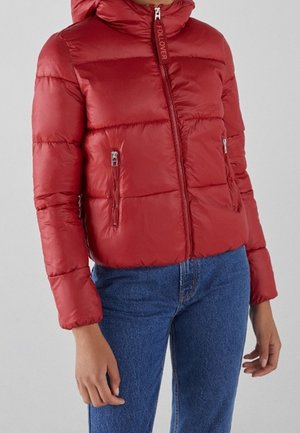 Chaqueta de plumas roja con capucha, diseño de acolchado, cierre frontal con cremallera y dos bolsillos con cremallera a los lados. Tejido suave y brillante.
