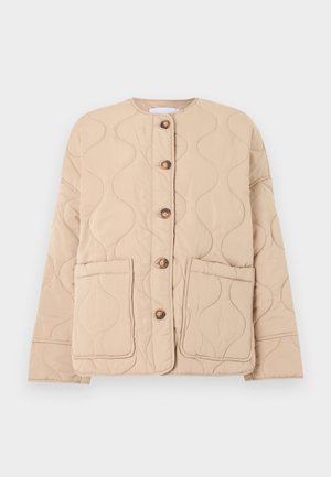 Veste matelassée beige avec un col rond, de grandes poches avant, cinq boutons marron et un motif ondulé cousu sur le tissu.