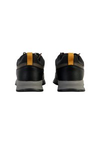 Scarpe da ginnastica nere con tomaia in pelle testurizzata, intersuola grigia e linguetta gialla sul tallone; design a profilo basso con lacci e suola in gomma.