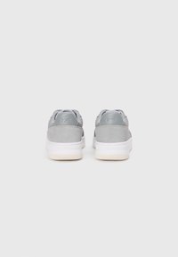 Graue Wildleder- und Ledersneaker mit einem strukturierten Rückenelement, gepolstertem Kragen, weißer Sohle und geprägt Logo an der Ferse.