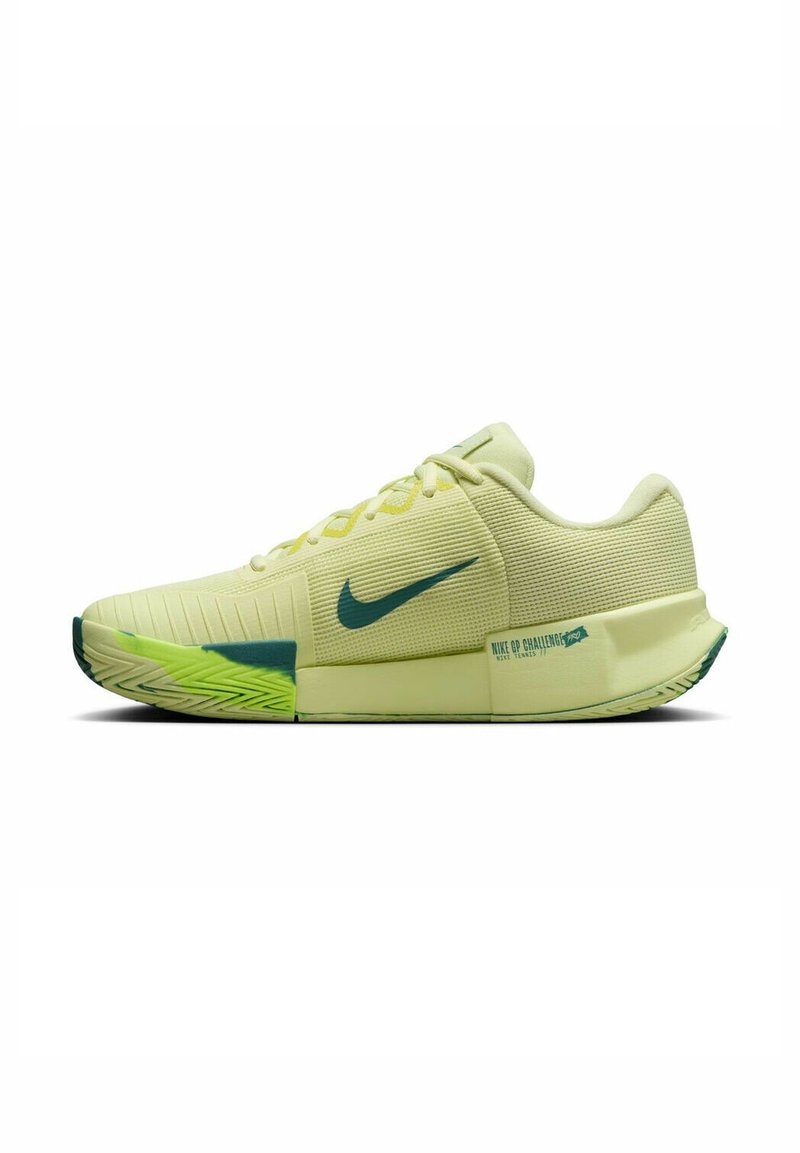 Baskets de sport jaune clair avec une tige texturée, des accents verts, un col rembourré et un logo swoosh en contraste de couleur vert foncé.