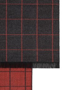 Wełniany szalik z ciemnoszarym tłem i czerwonym wzorem w kratę, zakończony frędzlami. Miękka tekstura, prostokątny kształt.
