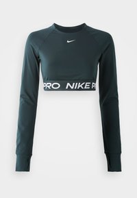 Czarna, ciemnozielona, krótka bluzka z długim rękawem, wykonana z elastycznego materiału. Posiada białe logo Nike oraz pas z napisem „PRO”. Otworki na kciuki przy mankietach.