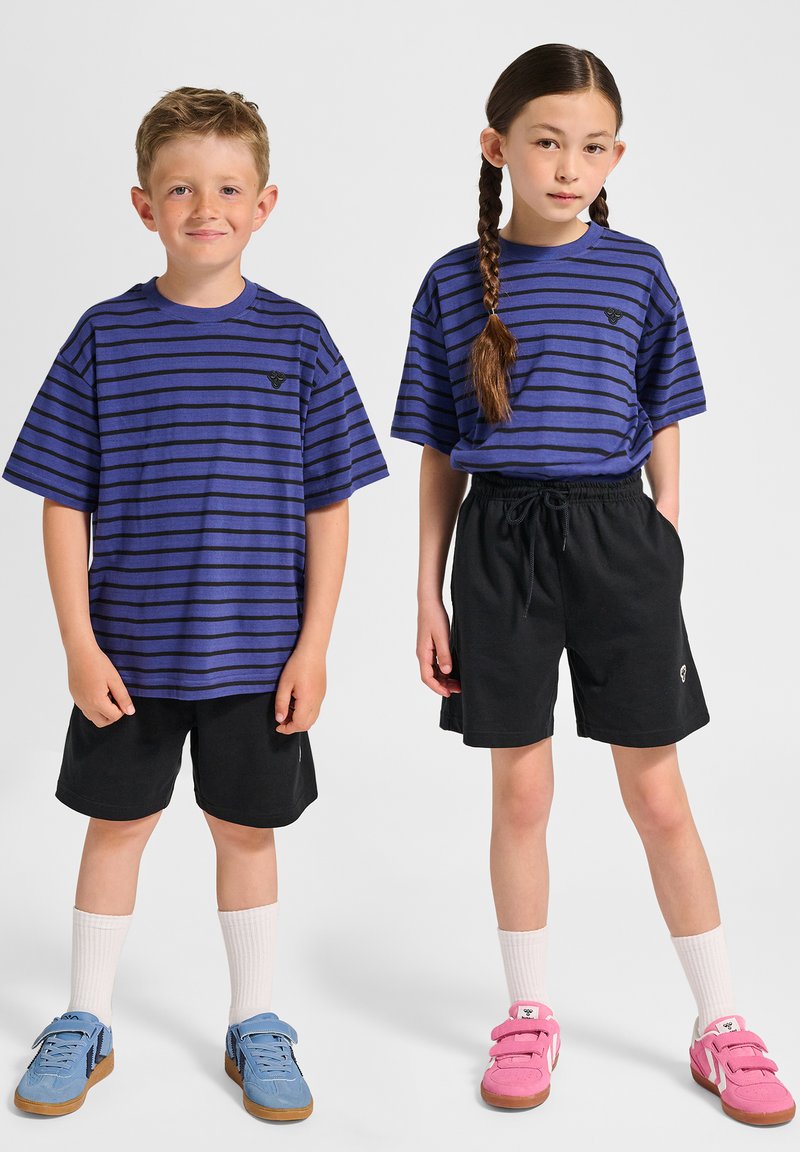 Blå och svarta randiga t-shirts, svarta shorts och färgglada skor. Pojken har ljusblå skor, flickan har rosa skor.