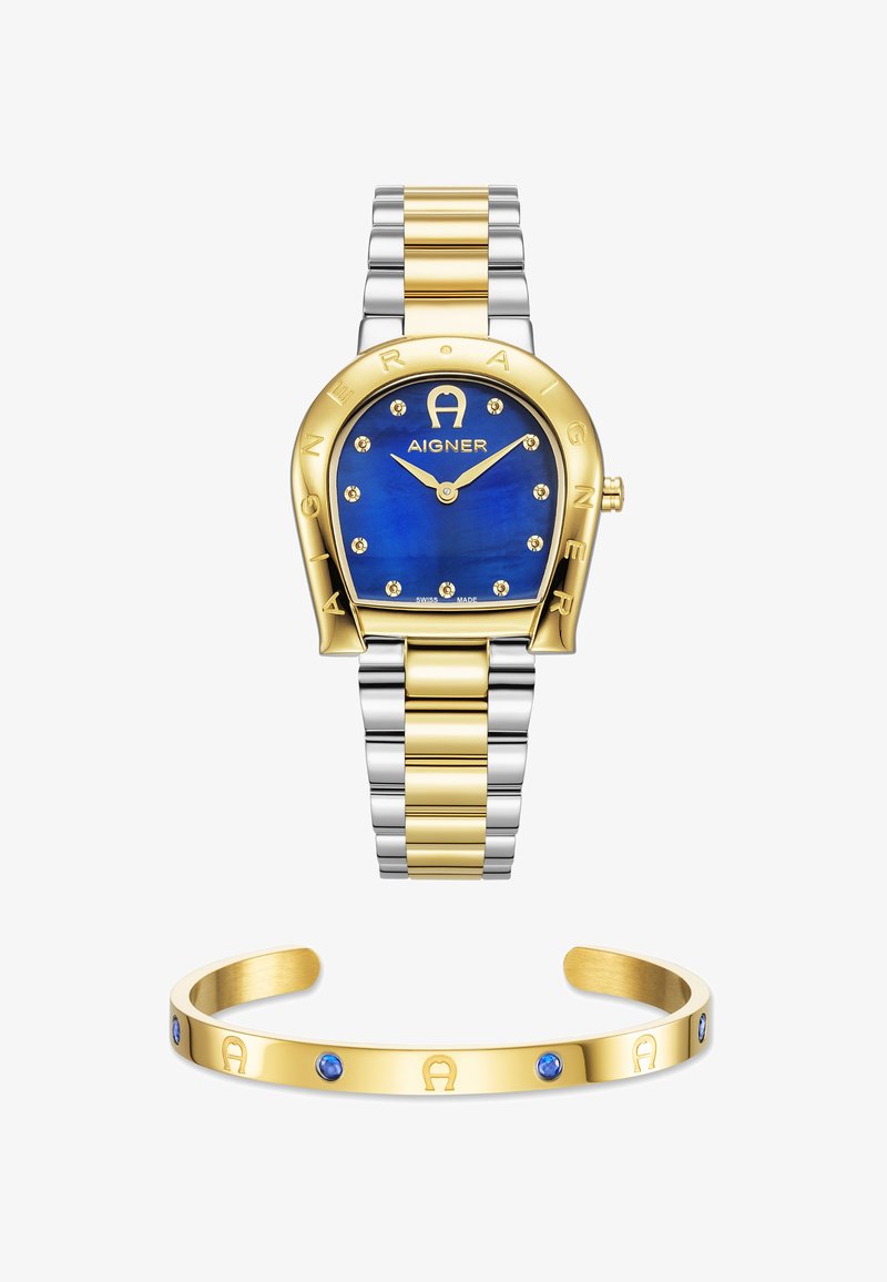 Guld- och silvertonad klocka med blå urtavla som har guldackenter och ädelstenar; åtföljd av ett guldarmband med blå stenar.