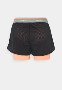 Pantalones cortos deportivos de malla negros con una capa de compresión interna color coral y una cinturilla gris impresa con "ONLY PLAY" en blanco.