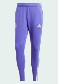 Purple athletic pants with a slim fit, featuring a yellow Adidas logo and Real Madrid crest on the front, made from smooth, stretchy material.