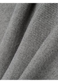 Grijze stof met een gestructureerde weving, met fijne, verheven patronen. Het materiaal lijkt zacht en lichtgewicht, geschikt voor kleding of bekleding.