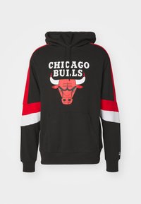 Felpa nera con maniche rosse e bianche. Sul davanti c'è un grande logo dei Chicago Bulls con un'immagine della testa di un toro. Realizzata in tessuto morbido.