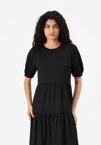 Vestido preto de manga curta feito de tecido suave, com um corpete ajustado e um design de saia fluida em camadas.