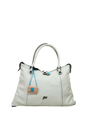 Sac à main en cuir blanc avec double poignée, coutures noires, tirettes de fermeture éclair avec accents bleus, et une petite étiquette beige suspendue à un cordon bleu.