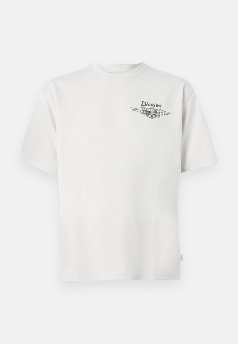 T-shirt blanc à manches courtes avec un petit logo "Dickies" et le logo ailé Harley-Davidson imprimés sur la poitrine gauche.