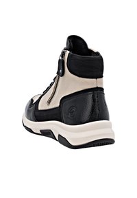 Des baskets montantes noir et beige présentent une finition en cuir texturé, des détails de fermeture éclair et une semelle blanche rembourrée. Accents de logo notables sur les côtés.