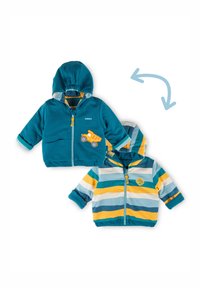 Due giacche a cappuccio reversibili per bambini piccoli, una tinta unita turchese con una toppa gialla a forma di camion, l'altra a righe con bande turchesi, gialle e bianche.