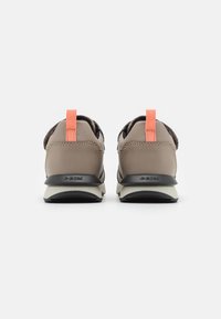 Sapatilhas desportivas castanhas e pretas com um upper de malha respirável, pega laranja, e sola de borracha texturizada com detalhe do logotipo.
