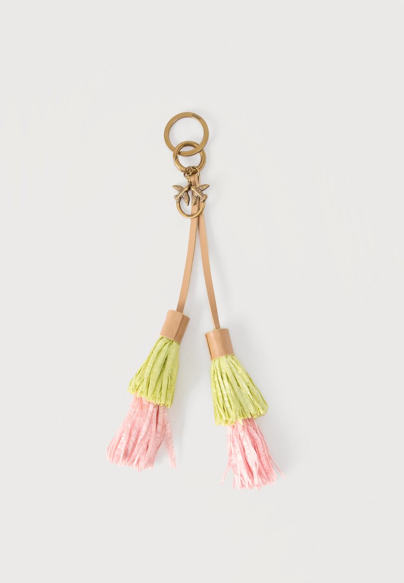 Χρυσό μπρελόκ με δύο ροζ και πράσινες φούντες που συνδέονται με δερμάτινα λουριά και δύο μικρά γούρια σε σχήμα πουλιού σε λευκό φόντο.