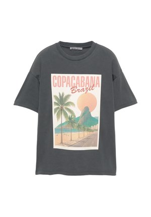 Gray oversized T-shirt with a printed graphic of Copacabana beach, featuring palm trees, a mountain, and a sun in pastel colors.