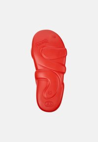 Red rubber sandal sole featuring an ergonomic design with soft curves, size 42, and embossed logo and details.