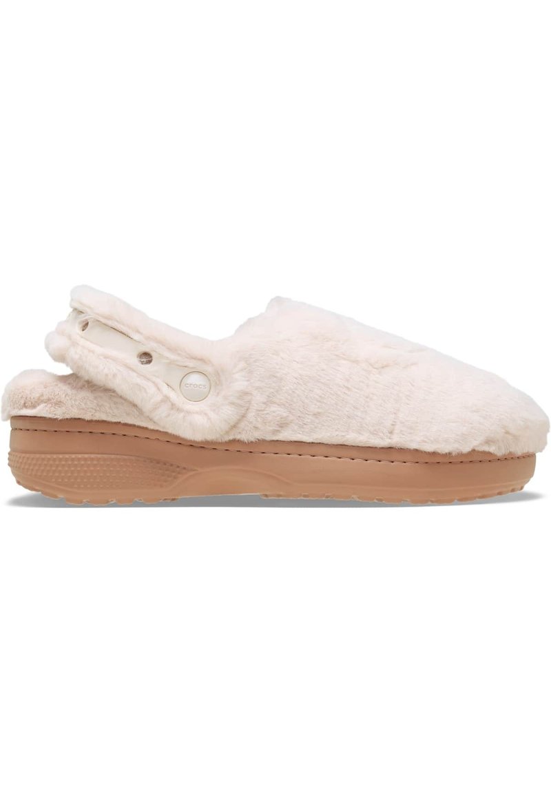 Chaussons blancs pelucheux avec une semelle en caoutchouc beige, design enfilement et accents de boutons sur le côté. La texture douce ajoute du confort.