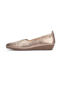 Zapatos de slip on de bronce metálico con punta redonda, superficie texturada, perforaciones sutiles y tacón bajo en cuña. Forro suave y minimalismo en los herrajes.