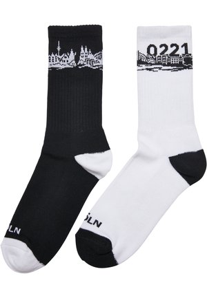 Socks i bomullsblandning, en svart och en vit, vardera med en stadssilhuett-design i svart upptill och kontrasterande tåsnygg.