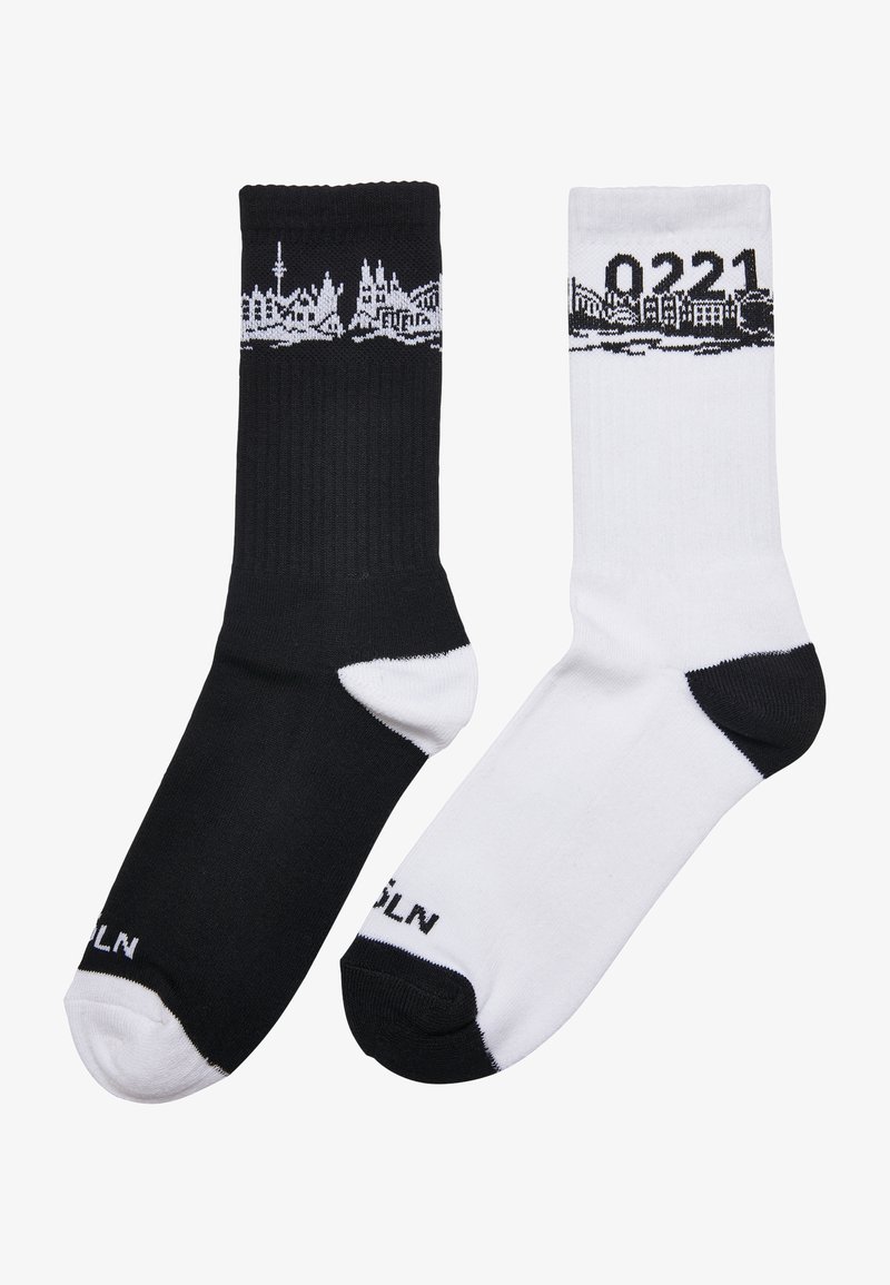 Cotton blend socks, one black and one white, each featuring a city skyline design in black at the top and contrasting toe accents.