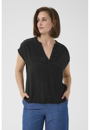 Black short-sleeve blouse with a V-neckline, made of lightweight fabric. Paired with blue denim wide-leg pants. Smooth texture, relaxed fit.