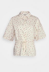 Camiseta de manga curta em tecido creme com estampado floral, apresentando uma frente com botões e um cordão na cintura para ajuste do tamanho.
