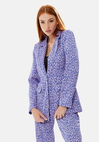 Purple blazer with a textured pattern of pink and navy shapes, featuring a notched lapel and two front pockets.