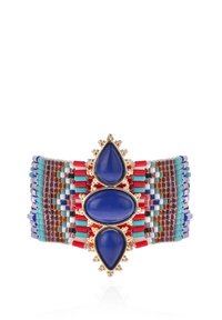 Bracelet à large bracelet ornée de perles en verre de couleurs rouge, turquoise et violet, agrémentée de trois cabochons en pierre bleue montés dans du métal couleur or.