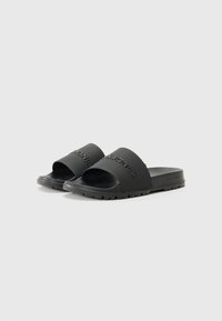 Infradito neri in gomma opaca, con una fascia larga con logo in rilievo, design open-toe e suola testurizzata per una presa migliore.