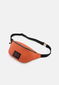 Orangene Bauchtasche mit schwarzem verstellbarem Gurt, Reißverschluss und einem rechteckigen schwarzen Patch mit der Aufschrift "STUDIO BERLIN" in weißen Buchstaben.