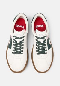 Sneakers bianche con accenti verdi e rosa, dotati di una parte superiore testurizzata, punta rotonda, lacci a contrasto e suola in gomma marrone.