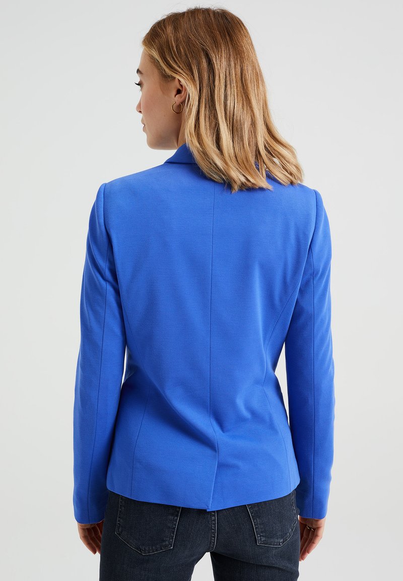 Blazer aus leuchtend blauem Stoff, mit tailliertem Schnitt, langen Ärmeln und einem Reverskragen mit Schlitzeinsatz im Rücken.