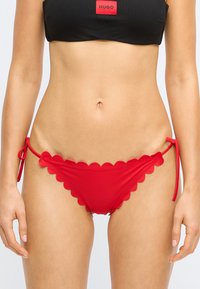 Punased bikiinipõhjad, millel on libisev äär ja reguleeritavad seotud külged, siledast kangast. Lihtne ja paremini istuv kujundus.
