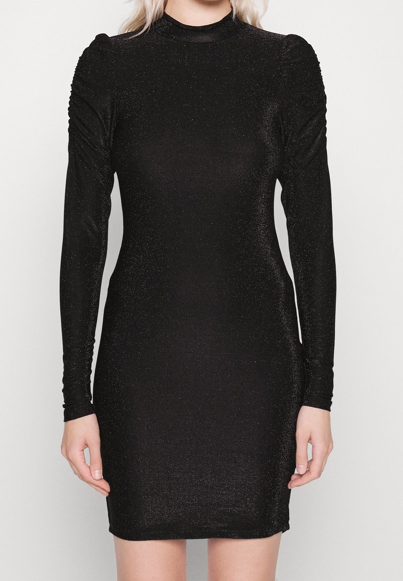 Svart långärmad klänning i glittrande material, med en figurnära silhuett och rynkade detaljer längs axlarna och ärmarna.