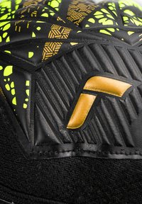 Guanto nero e giallo neon con texture, con motivi geometrici dorati e un logo dorato prominente su materiale imbottito.