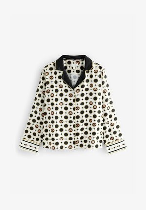 Biela košela s dlhým rukávom a čiernym golierom, ozdobená vzorom čiernych kruhov a ružových pier, doplnená čiernymi a zlatými geometrickými dizajnmi.