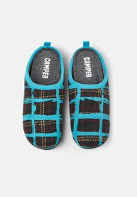 Två tofflor i slip-on-modell med ett svart och flerfärgat rutmönster med turkosa detaljer och en grå inredning. Varumärket syns inuti.