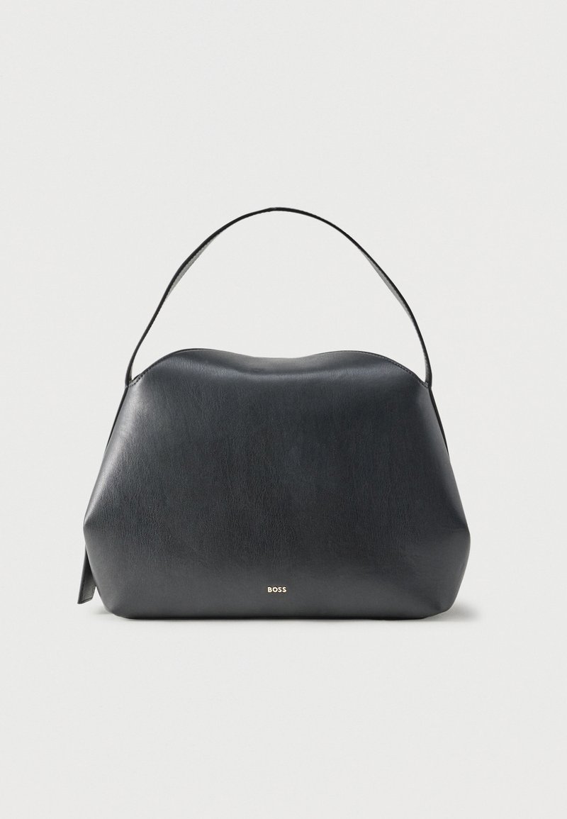 Sac à main en cuir noir avec une seule bandoulière et un petit logo doré "BOSS" à l'avant, sur un fond gris clair uni.
