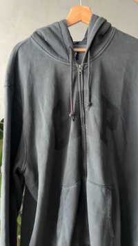 Haut à capuche zippé gris en tissu doux et brossé. Comprend une capuche, des poches avant et un grand logo GAP dans une teinte plus foncée sur le devant.