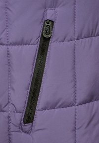 Lila Pufferjacke mit einer schwarzen Reißverschlusstasche. Sie hat eine gesteppte Textur und glattes Material, das das kontrastierende Reißverschlussdetail hervorhebt.