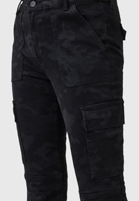 Pantalones cargo negros con un sutil patrón de camuflaje, que cuentan con múltiples bolsillos, corte recto y tejido de algodón duradero.