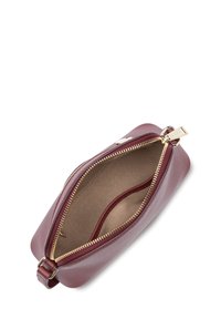 Borsetta in pelle bordeaux con zip dorata, forma rettangolare, texture liscia e un ampio interno caratterizzato da un design minimale.