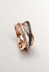 Anillo de oro rosa con bandas entrelazadas. Tres bandas tienen un acabado pulido, una adornada con cristales blancos y otra con acentos negros.