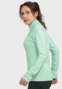 Mintgrünes, langärmliges Sportoberteil mit hohem Kragen. Verfügt über ein strukturierte Rippendesign und eine taillierte Silhouette. Logo der Marke auf der Schulter.