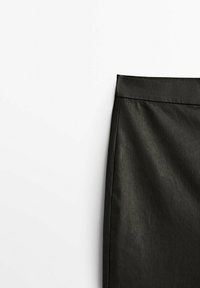 Svart blyertskjol med en mjuk, matt yta. Har en åtsittande midja och en ren, enkel design som avsmalnar ned mot kanten.